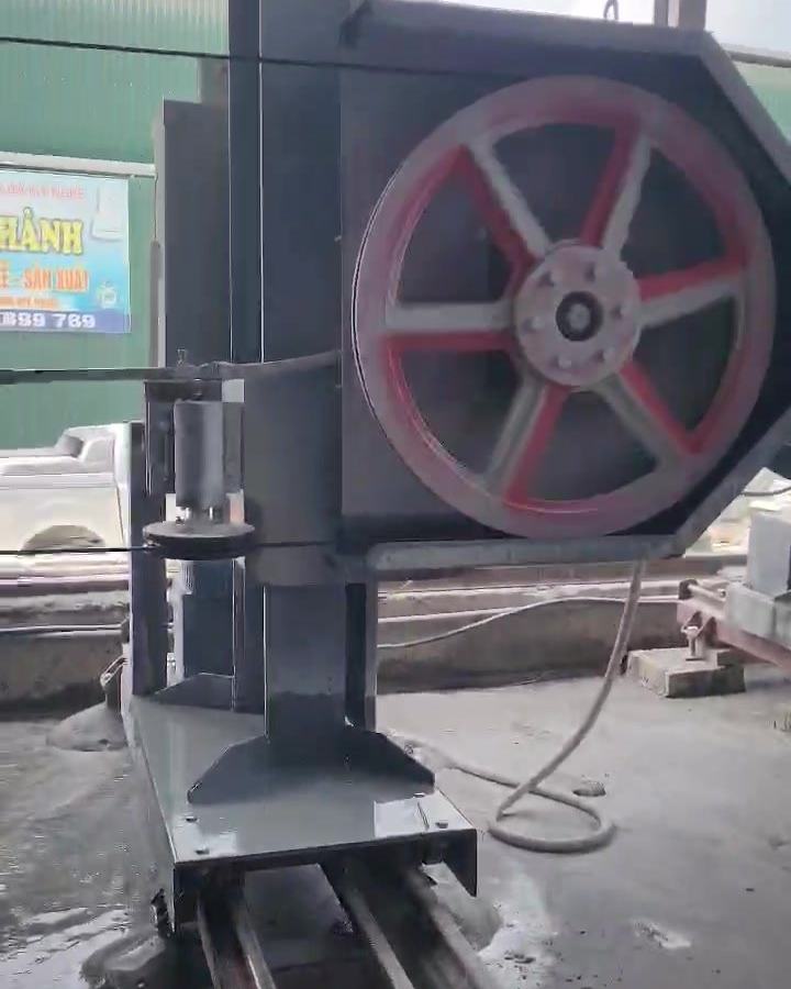 Cột máy cắt dây CNC Vitenda mang bánh đà dẫn dây, chạy trên ray tại xưởng đá
