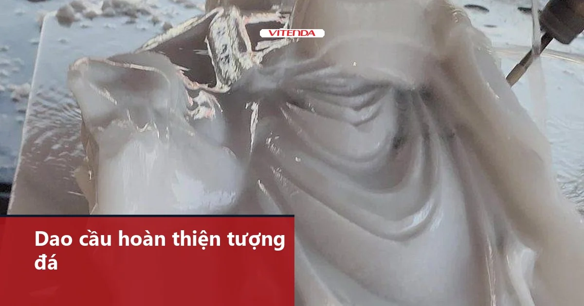 Tượng đá trắng đang được đục hoàn thiện, mũi dao ở góc phải ảnh, các nếp áo là mặt cong dao cầu CNC thường gia công