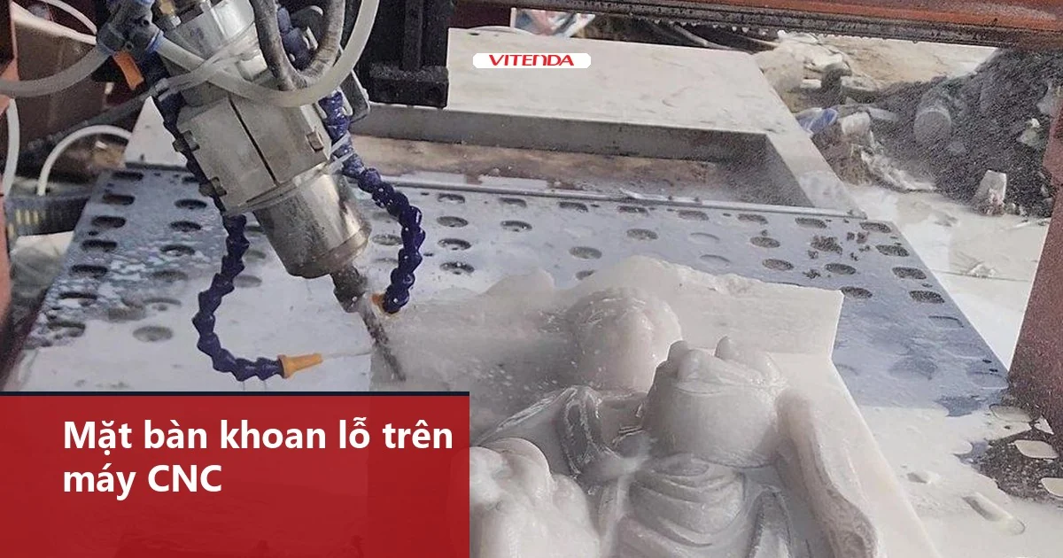 Mặt bàn khoan lỗ đều trên máy CNC, đầu dao đang gia công phôi đá đặt trên bàn