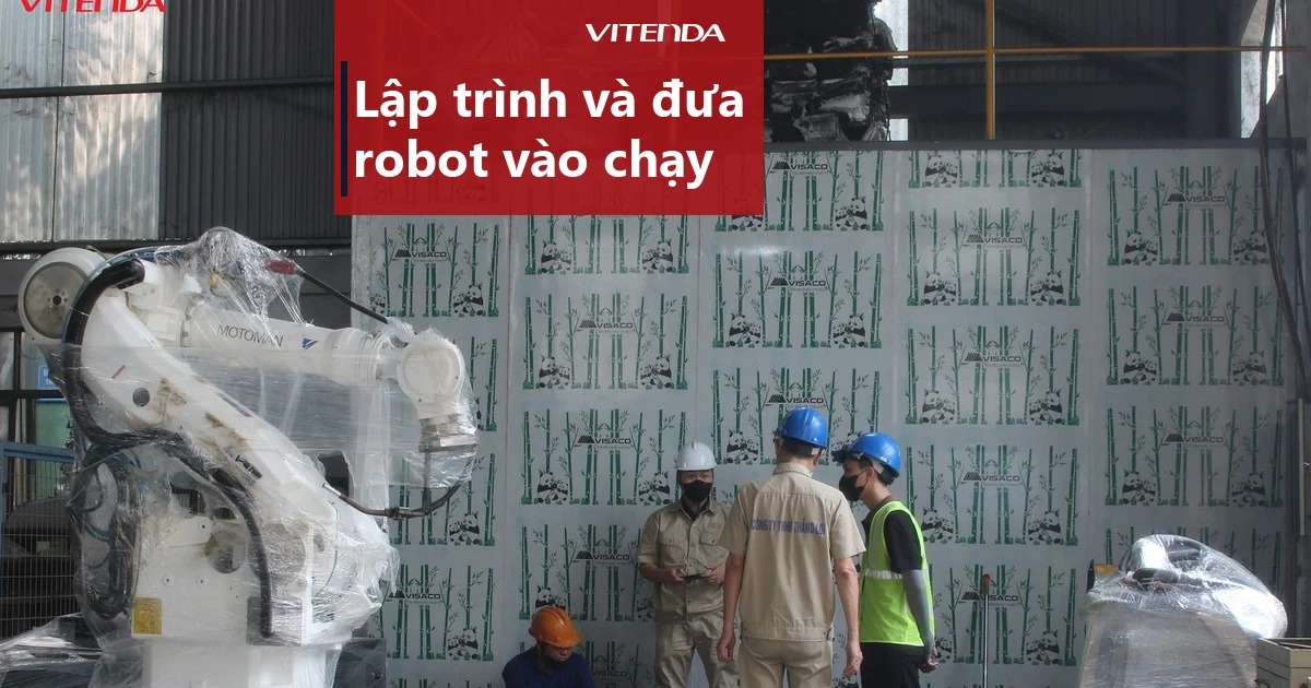 Robot hàn Motoman còn bọc nilon đang được lắp đặt tại xưởng, kỹ thuật viên đứng bên cạnh