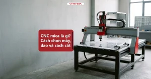 Minh hoạ máy CNC router cắt tấm mica trong suốt trong xưởng, phoi nhựa rải trên bàn máy