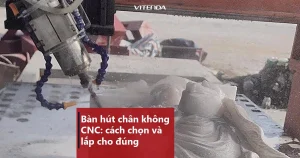 Đầu dao máy CNC đang gia công phôi đá đặt trên mặt bàn máy có hàng lỗ tròn