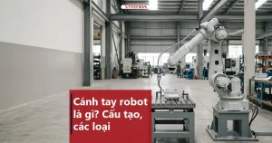 Hình minh hoạ cánh tay robot công nghiệp nhiều khớp đặt cạnh bàn gá trong xưởng cơ khí rộng, kèm tiêu đề bài